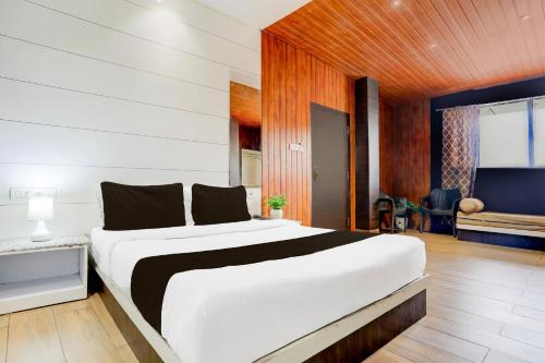 a bedroom with a large white bed with wooden walls at Super Collection O Jaigaon Near Bhutan Gate in Phuntsholing