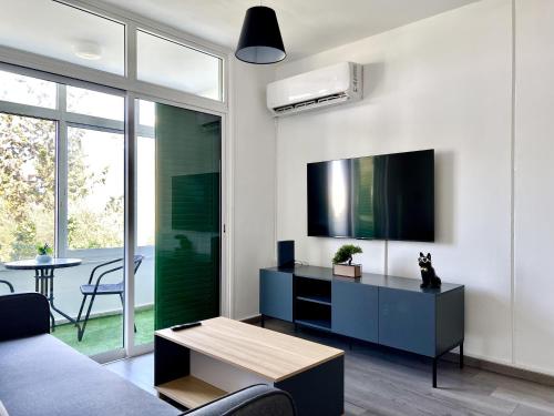 a living room with a couch and a tv and a table at Fully Equipped One Bedroom APT in Limassol