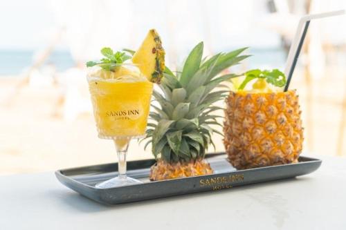 a tray with two cocktails and two pineapples on a table at Sands Inn Hotel in Pwani Mchangani