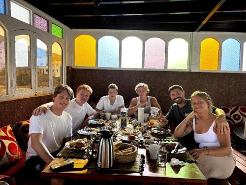 a group of people sitting around a table in a restaurant at Dar Surfana Morocco in Aourir