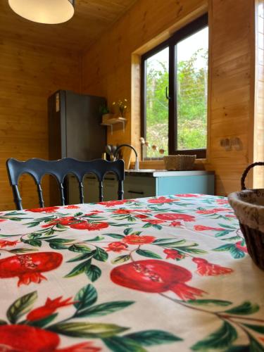a kitchen with a table with a flower blanket on it at Balda Novel House in Martvili