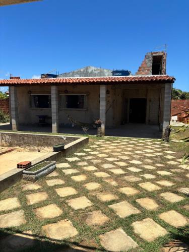 a house with a stone patio in front of it at Casa de Praia em Abaís in Estância