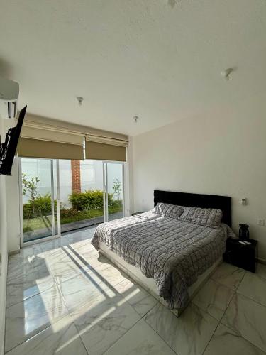 a bedroom with a bed and a large window at Casa Girasol in Oaxtepec