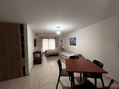 a bedroom with a bed and a table and chairs at Monoambiente centrico Plaza Belgrano in San Salvador de Jujuy