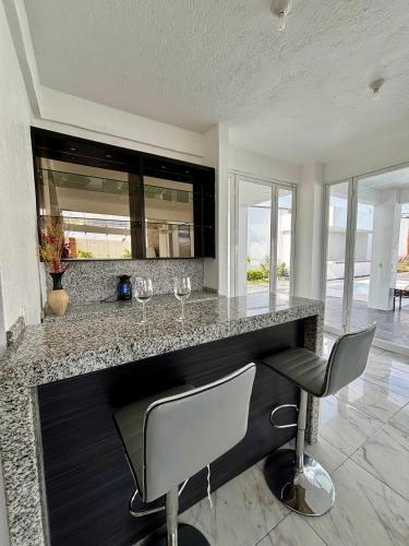 a kitchen with a counter with two wine glasses at Casa Girasol in Oaxtepec
