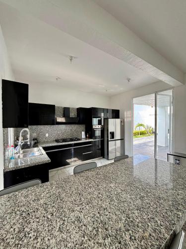 a kitchen with black and white appliances and a counter at Casa Girasol in Oaxtepec