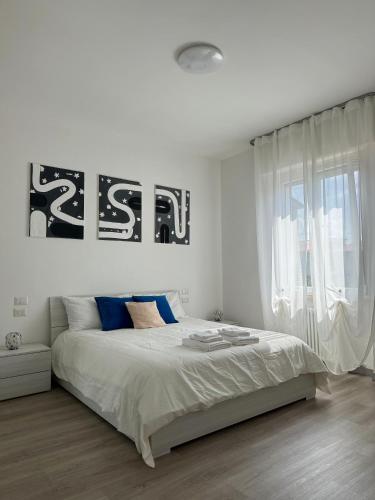 a white bedroom with a bed with a sign on the wall at Cecilia Sirmione Appartamento in Sirmione