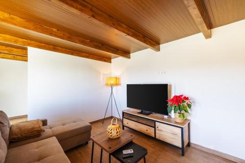 a living room with a couch and a flat screen tv at Penthouse with a View in El Palmital