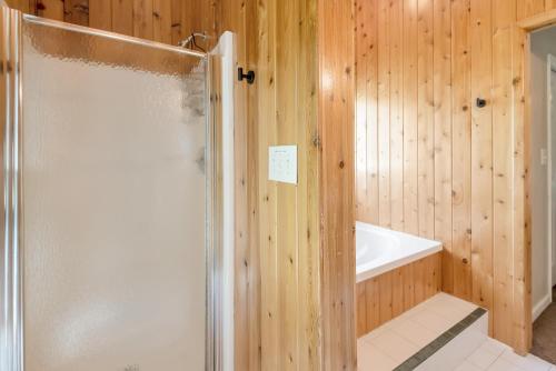 a wooden bathroom with a shower and a tub at Cozy Cabin Right on the New River in Todd - Easy River Access - Fire Pit in Brownwood