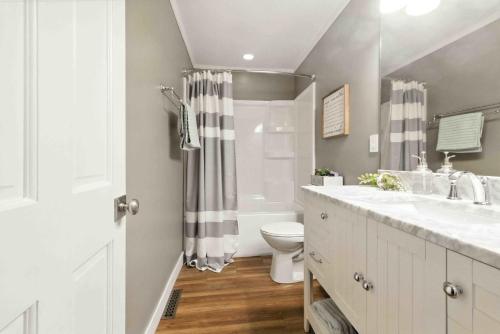 a white bathroom with a sink and a toilet at Hartley Lake Hideaway - The Perfect Getaway! in Brainerd