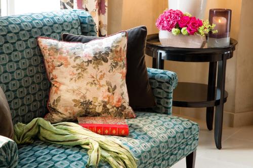 a chair with a pillow and a table with flowers at Les Tournelles in Paris