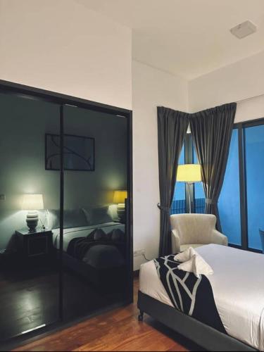 a bedroom with a bed and a chair and windows at The Luxe By klcc infinitum in Kuala Lumpur