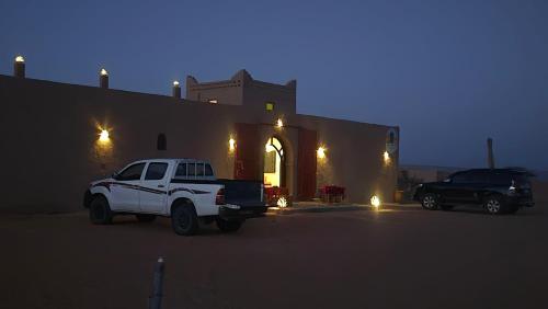 a white truck parked in front of a building at Riad Ouzina TGM in Ouzina