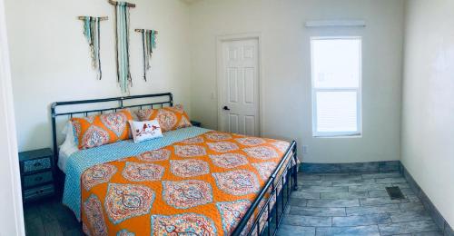 1 dormitorio con 1 cama con edredón de naranja y ventana en ️Discounted couples setupFULL KITCHEN near canyons CLEANBoat Parking, en Page