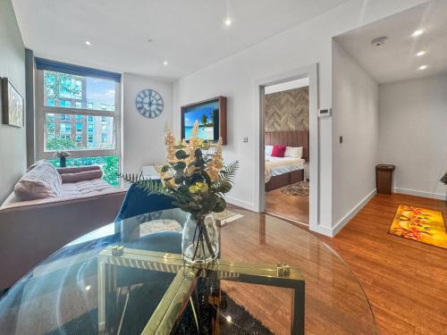 a living room with a vase of flowers on a glass table at Marvel House in Milton Keynes
