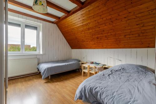 ein Schlafzimmer mit Bett, Schreibtisch und Fenster in der Unterkunft Maison Le Nid de Cigognes in Witternheim