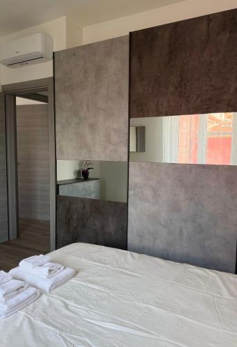 a bedroom with a white bed with towels on it at Cecilia Sirmione Appartamento in Sirmione