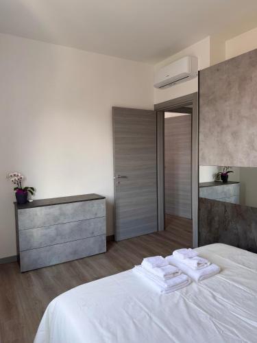 a bedroom with a white bed with towels on it at Cecilia Sirmione Appartamento in Sirmione