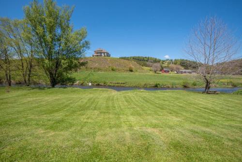 a grassy field with a pond and a building on a hill at River Access, VIEWS, Sleeps 8, Fire Pit in Brownwood
