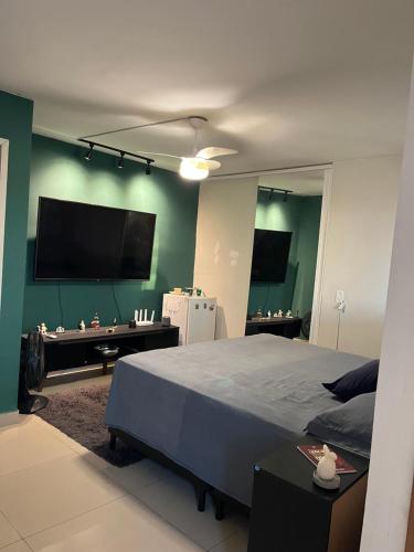 a bedroom with a large bed and a flat screen tv at Apartamento Amplo in Natal