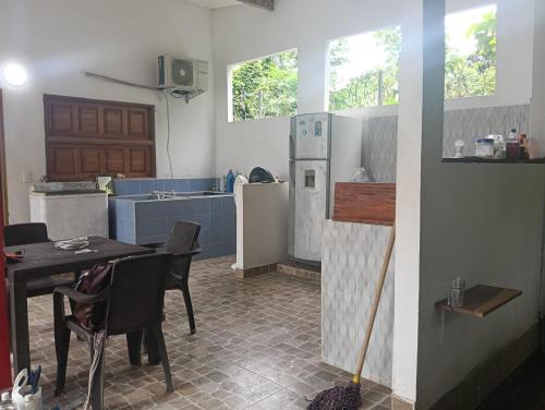 a kitchen with a table with chairs and a refrigerator at Cabaña velez in Capurganá