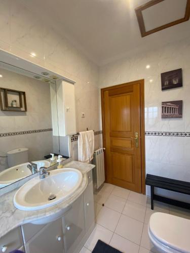 a bathroom with a sink and a toilet and a mirror at Vivenda Juliano Freitas in Atães