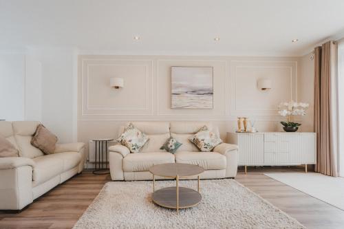 a living room with two white couches and a table at Modern town house in Ramsgate
