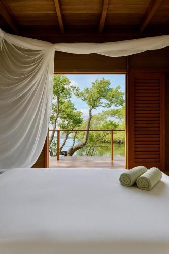 a bedroom with a bed with two pillows and a window at Villa Luzo & Tours in Saonek