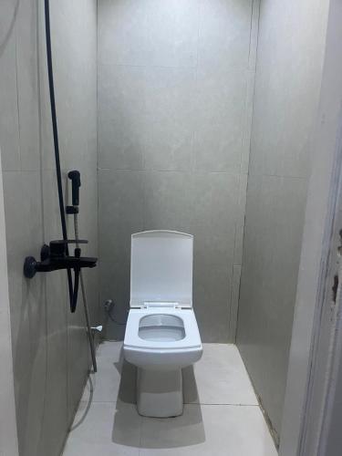 a bathroom with a white toilet in a stall at Room in Aread in Riyadh