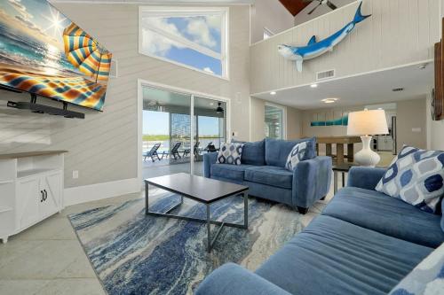 a living room with two blue couches and a table at Manatee By The Bay in Crystal River
