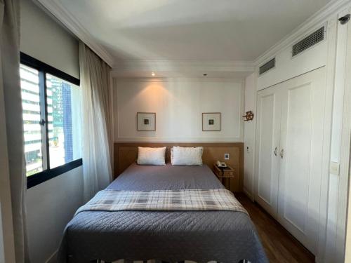 Un dormitorio con una cama en una habitación con ventana. en Hotel Inter Jardins UH1607, en São Paulo