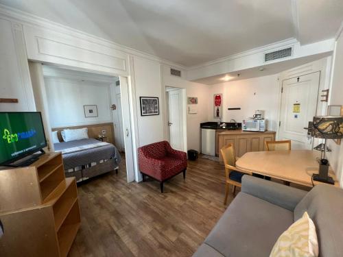 a living room with a bed and a dining room at Hotel Inter Jardins UH1607 in São Paulo