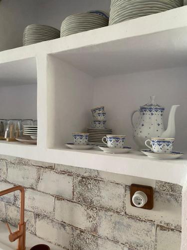 a shelf with blue and white cups and plates at El Masico Rural in Olba