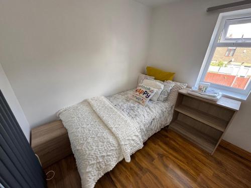 a small bedroom with a bed and a window at Willow Tree Retreat Airport Friendly 3BR House, with Garden & Office in Northolt