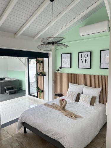 a bedroom with a large bed with a pendant at Obuncoeur avec spa in Le Gosier