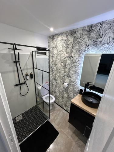 a bathroom with a shower with a toilet and a sink at Obuncoeur avec spa in Le Gosier