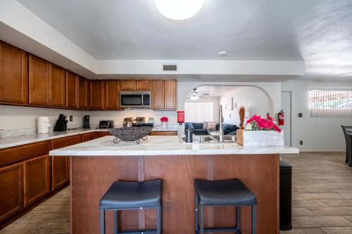 a kitchen with a large island with two bar stools at The Family Friendly Funhouse in Phoenix