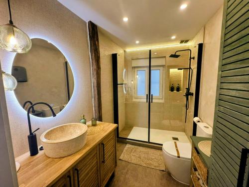 a bathroom with a sink and a toilet and a mirror at La Fuente del Kiko in Orduña