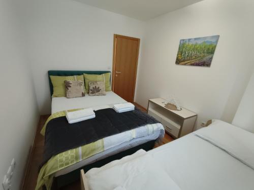a small room with two beds and a night stand at My Place in Donje Mladice