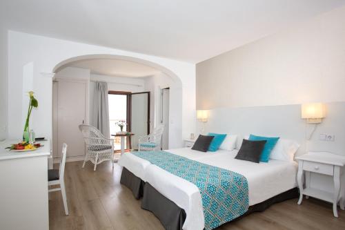 a hotel room with a large bed and a desk at Hotel Marina in Port de Soller