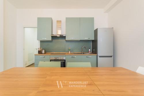 a kitchen with blue cabinets and a wooden table at Wanderlust Experience Le dimore di Alice in Bitonto