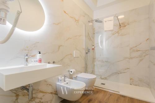 a bathroom with a sink and a toilet and a shower at Wanderlust Experience Le dimore di Alice in Bitonto