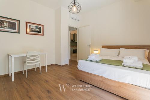 a bedroom with a bed and a table and a chair at Wanderlust Experience Le dimore di Alice in Bitonto