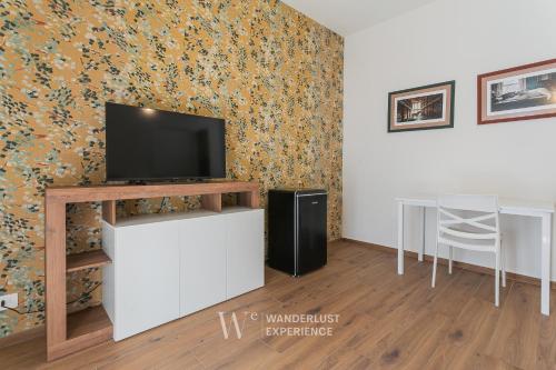a living room with a flat screen tv on a stand at Wanderlust Experience Le dimore di Alice in Bitonto