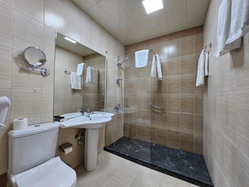 a bathroom with a toilet and a sink and a shower at Crown Suites in Baku