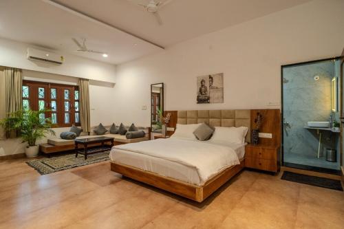 a bedroom with a large bed and a couch at The Medona - A Peaceful Farmstay in Thūr