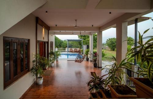 a hallway with potted plants and a swimming pool at The Medona - A Peaceful Farmstay in Thūr