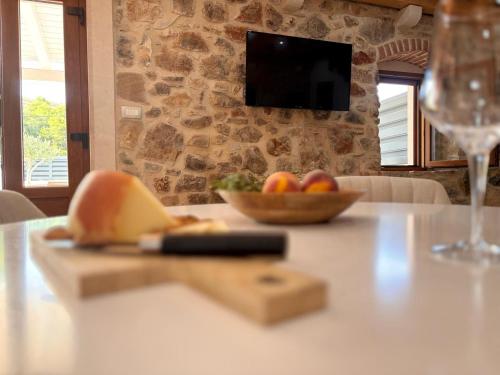 a table with a bowl of fruit and a wine glass at Casa Rustivéra - Island Hvar in Vrbanj