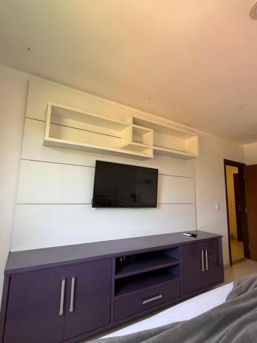 a living room with a tv on a wall at Casa Ribeiro Morro de São Paulo in Morro de São Paulo