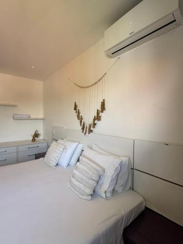a bedroom with a white bed with white pillows at Casa Ribeiro Morro de São Paulo in Morro de São Paulo